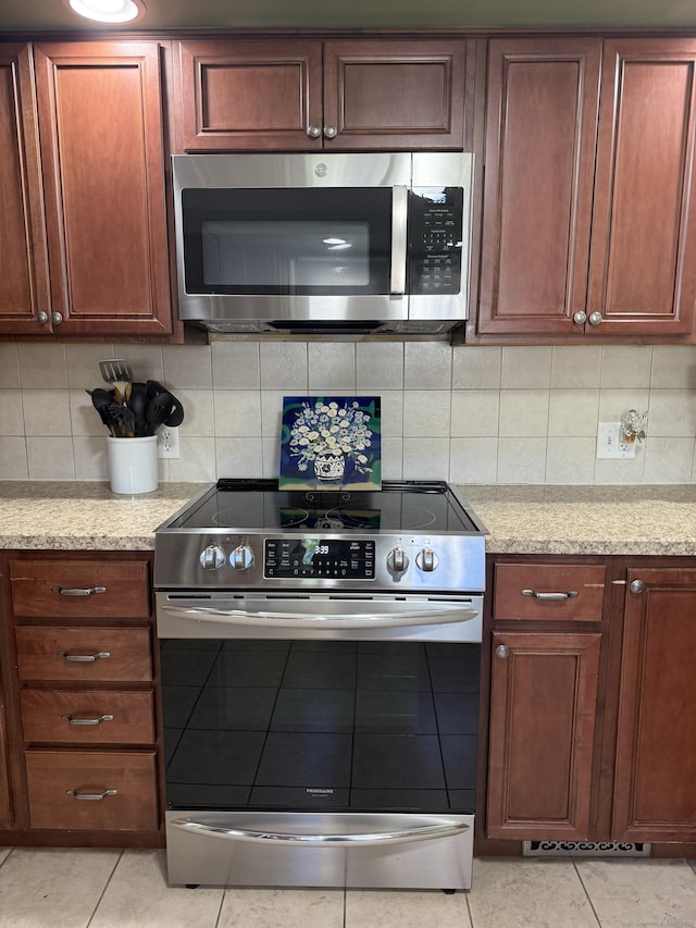 30 May St, Meriden, CT 06451 - kitchen with stainless steel appliances, light tile patterned floors, light stone counters, and backsplash