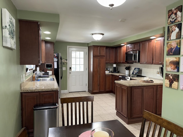 30 May St, Meriden, CT 06451 - kitchen with appliances with stainless steel finishes, a sink, light tile patterned floors, tasteful backsplash, and a peninsula