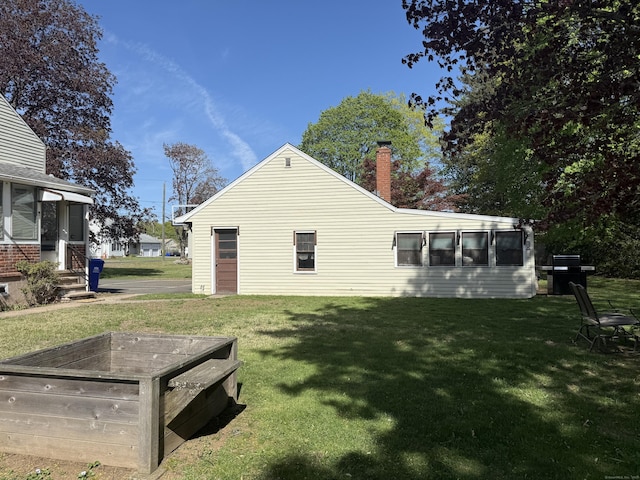 30 May St, Meriden, CT 06451 - rear view of house featuring a chimney, a lawn, and a sunroom