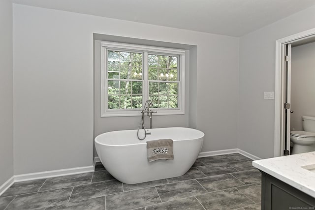 684 Aspen Ln, Orange, CT 06477 - bathroom with a freestanding tub, toilet, and baseboards