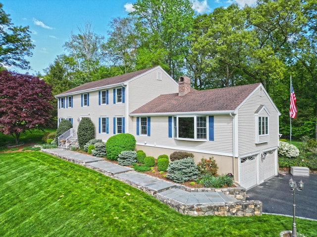 684 Aspen Ln, Orange, CT 06477 - colonial house featuring a chimney, an attached garage, driveway, a front lawn, and a shingled roof