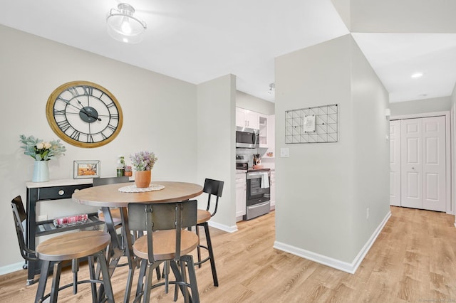 dining room featuring light wood-type flooring and baseboards
