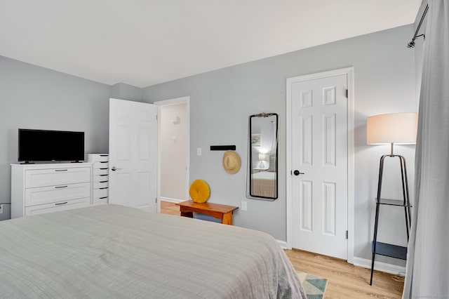 bedroom featuring light wood-style floors and baseboards