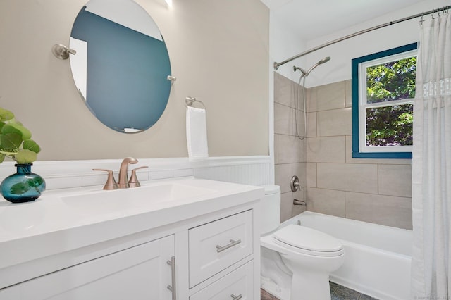 bathroom with vanity, toilet, shower / bathtub combination with curtain, and wainscoting