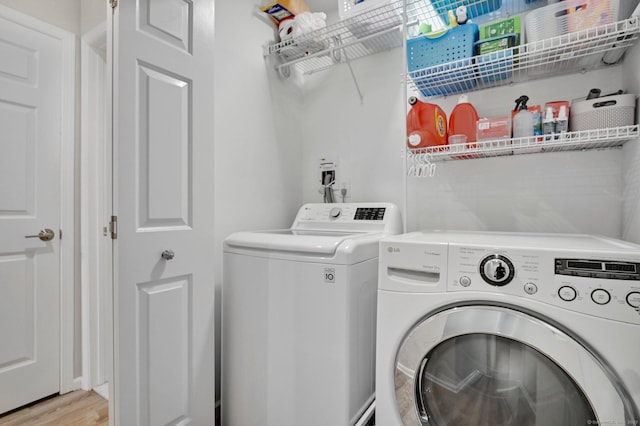washroom with separate washer and dryer and light wood-style floors