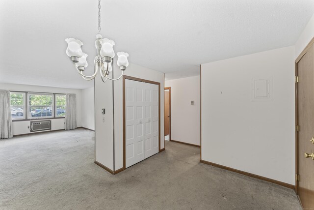 unfurnished dining area with a chandelier, carpet flooring, a wall mounted air conditioner, and baseboards