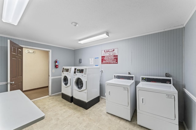 communal laundry room with washer and clothes dryer, crown molding, light flooring, and a textured ceiling