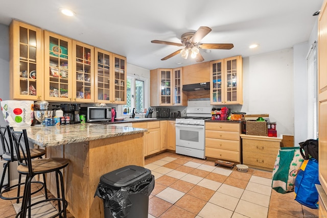 77 Cedar St, Norwalk, CT 06854 - kitchen featuring white range with gas cooktop, stainless steel microwave, a peninsula, under cabinet range hood, and glass insert cabinets