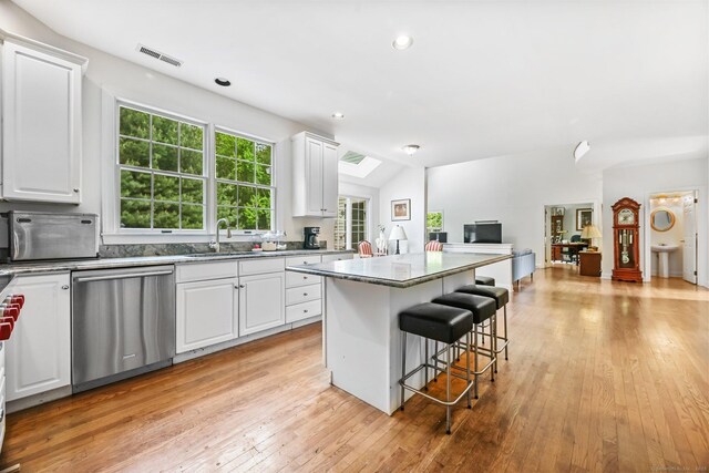 260 Range Rd, Fairfield, CT 06890 - kitchen featuring stainless steel dishwasher, a center island, open floor plan, a kitchen bar, and light wood-style floors