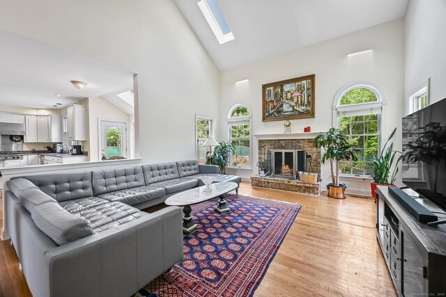 260 Range Rd, Fairfield, CT 06890 - living area featuring high vaulted ceiling, light wood-type flooring, a fireplace, and a skylight