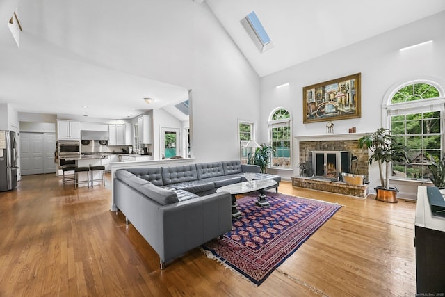 260 Range Rd, Fairfield, CT 06890 - living room featuring high vaulted ceiling, wood finished floors, a brick fireplace, and a skylight