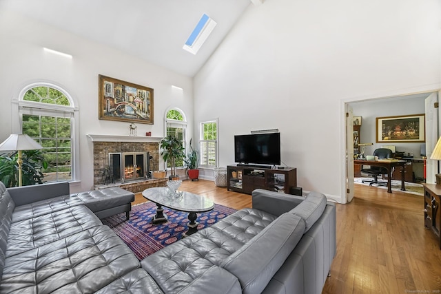 260 Range Rd, Fairfield, CT 06890 - living room featuring high vaulted ceiling, wood finished floors, a skylight, and a lit fireplace
