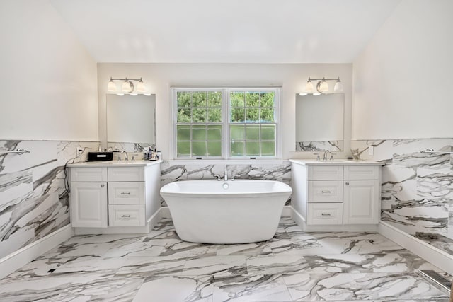 260 Range Rd, Fairfield, CT 06890 - full bath featuring tile walls, wainscoting, a soaking tub, two vanities, and marble finish floors