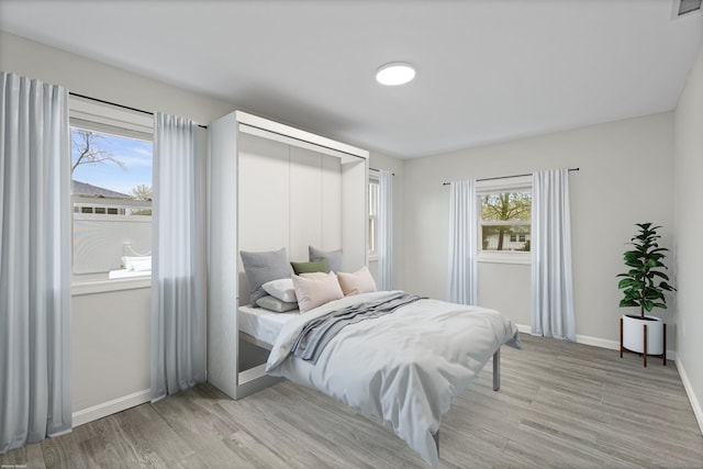 bedroom with light wood finished floors and baseboards