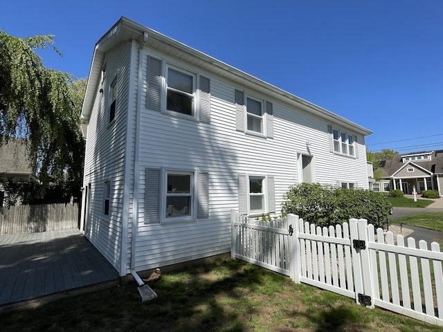 back of house featuring fence and a wooden deck