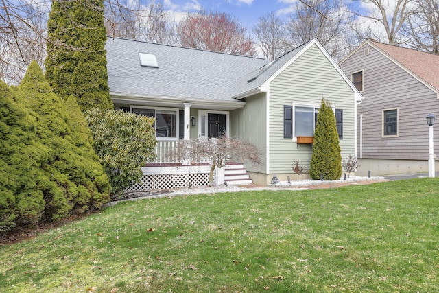view of front of house featuring covered porch, a front lawn, and a shingled roof