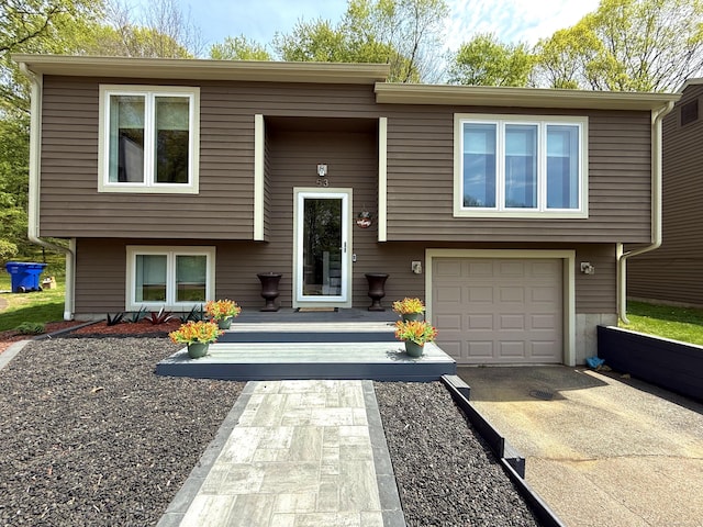 raised ranch with an attached garage and driveway