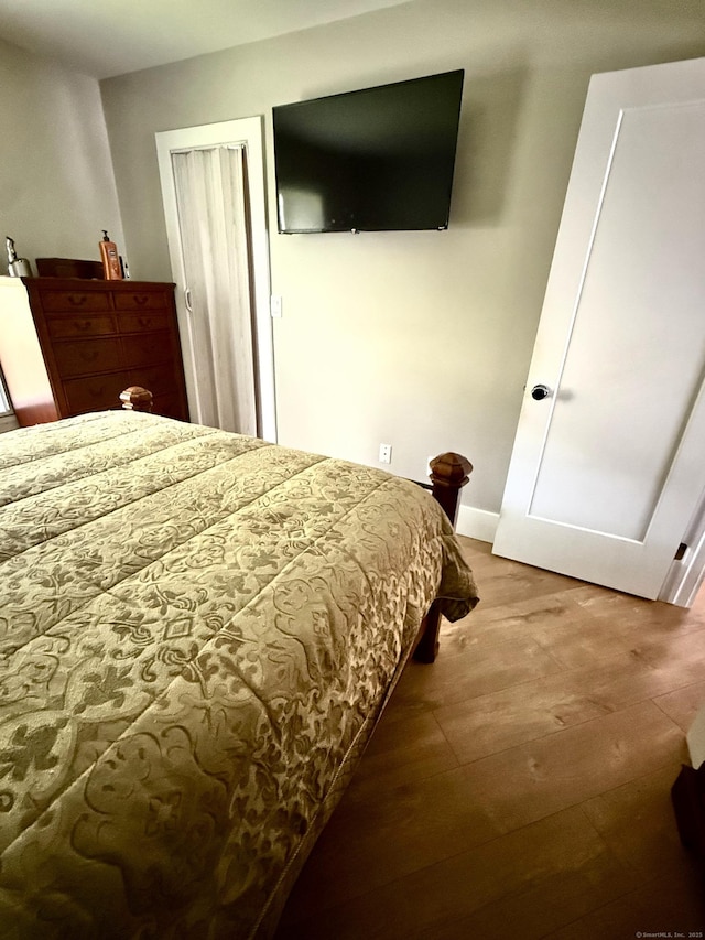 bedroom with baseboards and wood finished floors