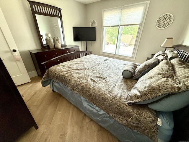 bedroom with baseboards and wood finished floors
