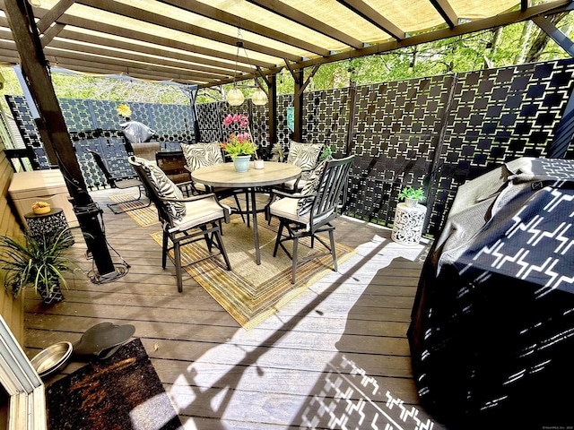 wooden terrace with a fenced backyard and outdoor dining area