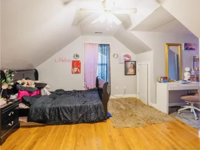 bedroom featuring wood finished floors, lofted ceiling, and ceiling fan