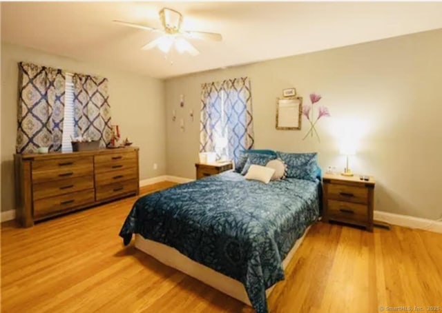bedroom with wood finished floors, baseboards, and ceiling fan