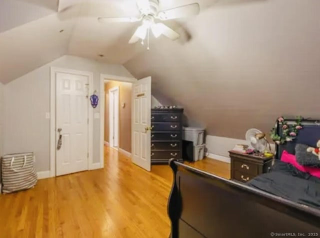 bedroom featuring lofted ceiling, ceiling fan, baseboards, and light wood-type flooring