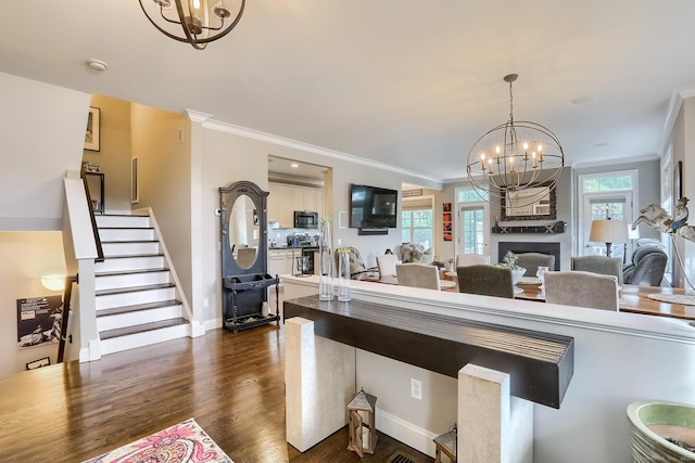 kitchen with a chandelier, black microwave, dark wood-type flooring, hanging light fixtures, and white cabinetry
