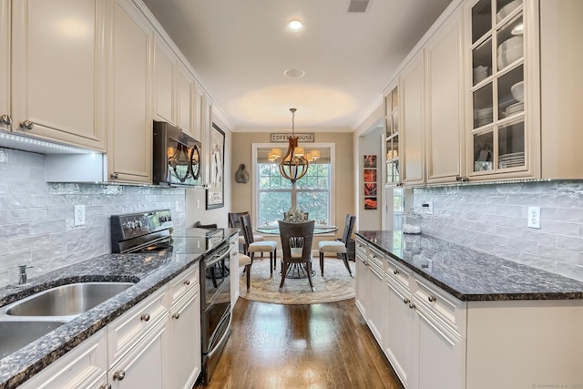 kitchen with black electric range, dark wood finished floors, tasteful backsplash, a chandelier, and crown molding