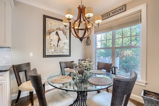 dining room with a chandelier, crown molding, baseboards, and wood finished floors