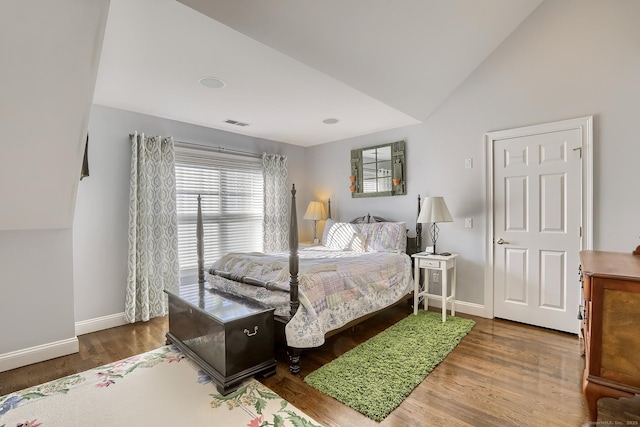 bedroom featuring vaulted ceiling, baseboards, and wood finished floors
