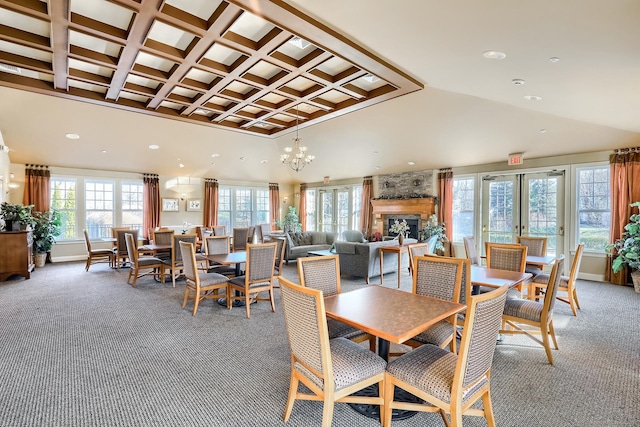 dining space featuring carpet floors, coffered ceiling, recessed lighting, beam ceiling, and a stone fireplace