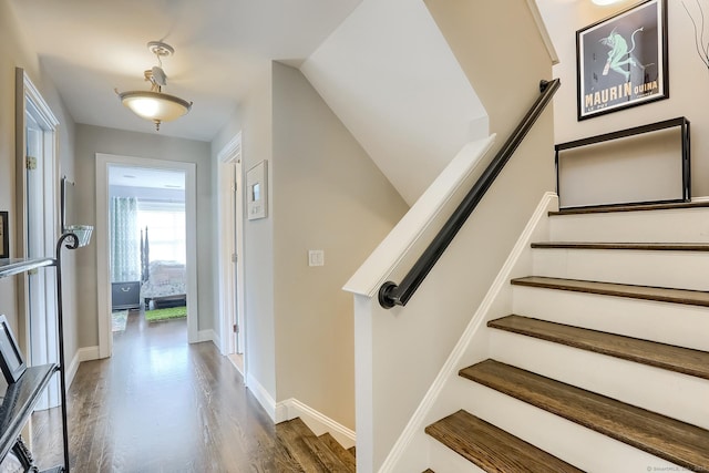 staircase with wood finished floors and baseboards