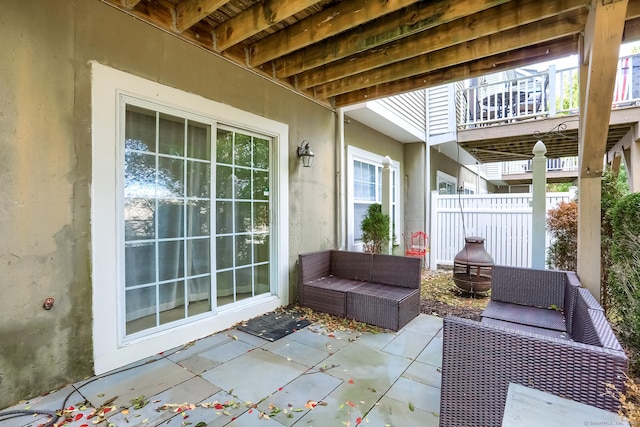 view of patio featuring an outdoor living space, fence, and a deck