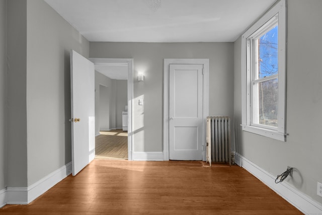 143 Putnam St, Hartford, CT 06106 - unfurnished bedroom with wood finished floors, baseboards, multiple windows, and radiator heating unit