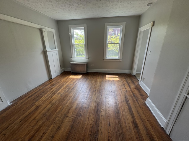 143 Putnam St, Hartford, CT 06106 - unfurnished bedroom with a textured ceiling, baseboards, and dark wood-style floors