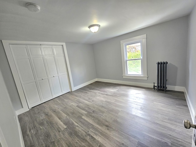 1 Arlington Hts, Norwich, CT 06360 - unfurnished bedroom featuring radiator heating unit, baseboards, wood finished floors, and a closet