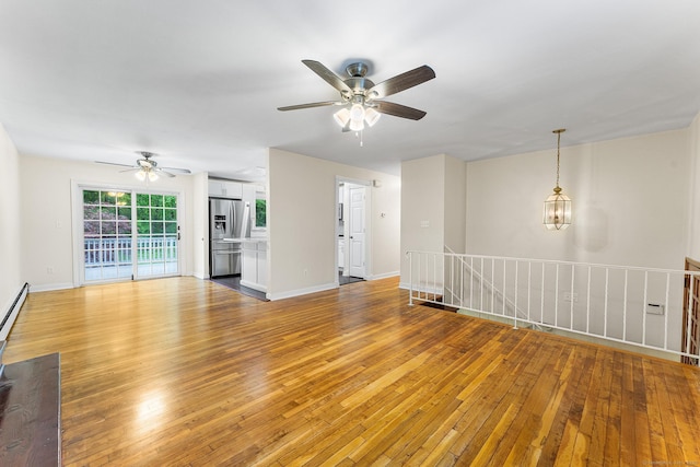 unfurnished living room featuring ceiling fan, light wood-type flooring, and baseboards