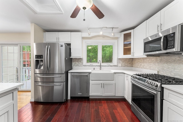 kitchen with stainless steel appliances, a sink, light countertops, white cabinetry, and plenty of natural light