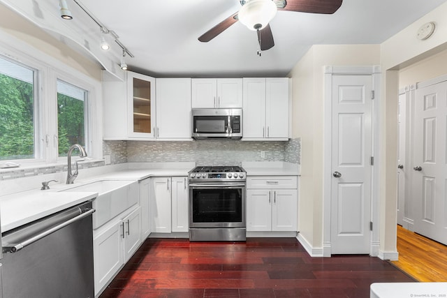 kitchen with appliances with stainless steel finishes, light countertops, and glass insert cabinets