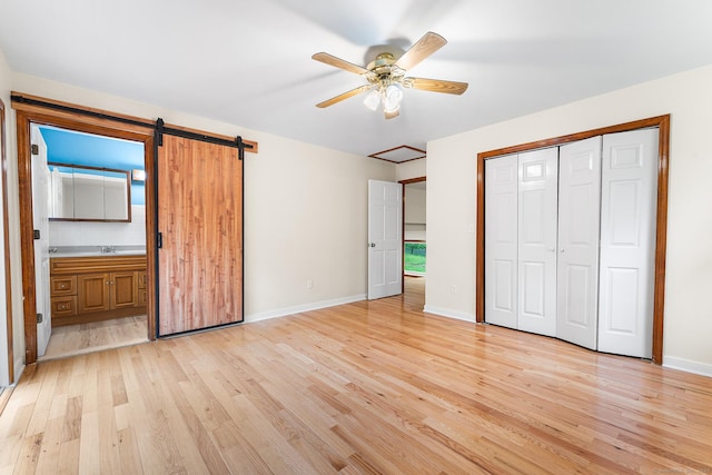unfurnished bedroom with light wood-style floors, a closet, baseboards, and ensuite bath