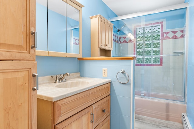 bathroom with baseboard heating, combined bath / shower with glass door, and vanity