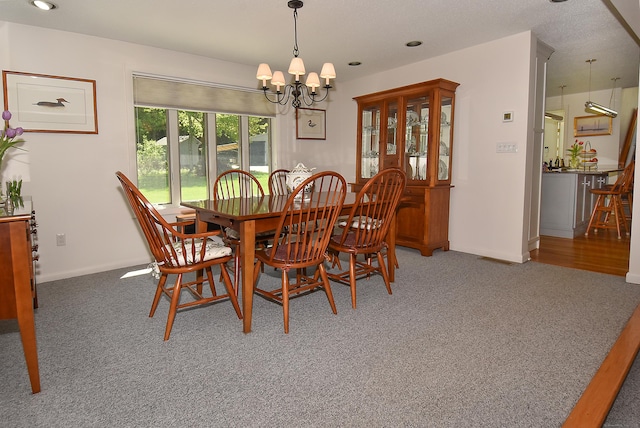 carpeted dining room with a chandelier, baseboards, and recessed lighting