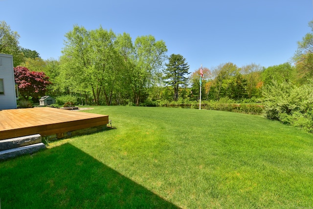 view of grassy yard featuring a wooden deck
