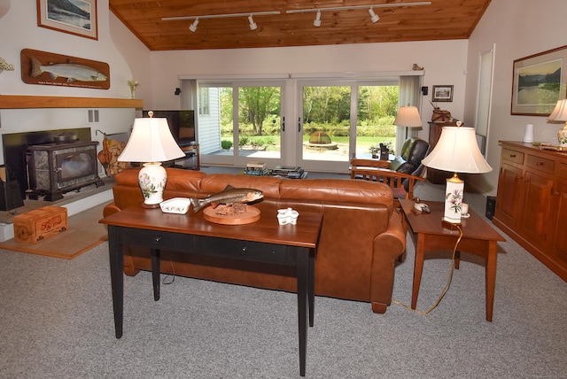 carpeted living area featuring track lighting, wooden ceiling, a wood stove, and lofted ceiling