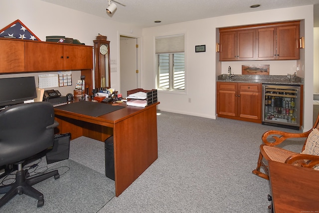 carpeted office featuring wine cooler, wet bar, and baseboards