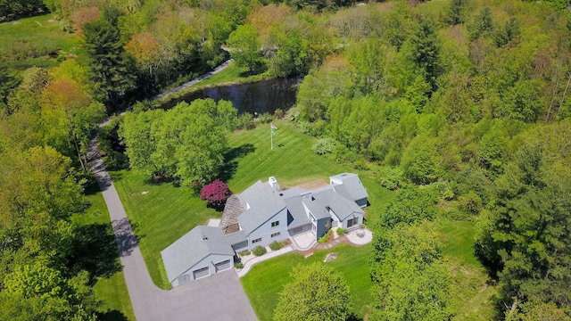 view from above of property with a nearby body of water and a forest