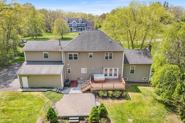 back of property with a wooden deck, french doors, a lawn, central air condition unit, and a chimney