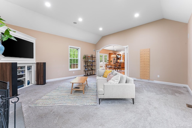 carpeted living area with arched walkways, vaulted ceiling, recessed lighting, baseboards, and ornate columns
