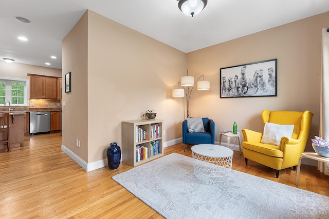 sitting room with baseboards, light wood finished floors, and recessed lighting
